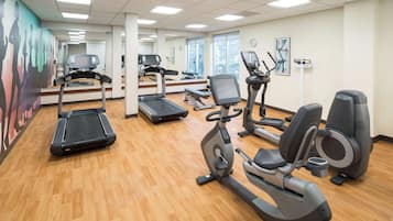A gym with treadmills, stationary bikes, and elliptical machines.