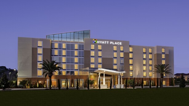 Un hotel moderno a più piani, con un cartello ben visibile con la scritta "HYATT PLACE".