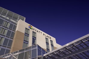 Ein modernes Gebäude mit dem Schriftzug "HYATT PLACE" an der Fassade.