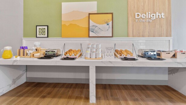 A breakfast bar with various food items and a sign saying "Delight in the day". - Spark by Hilton San Antonio Dominion (San Antonio)