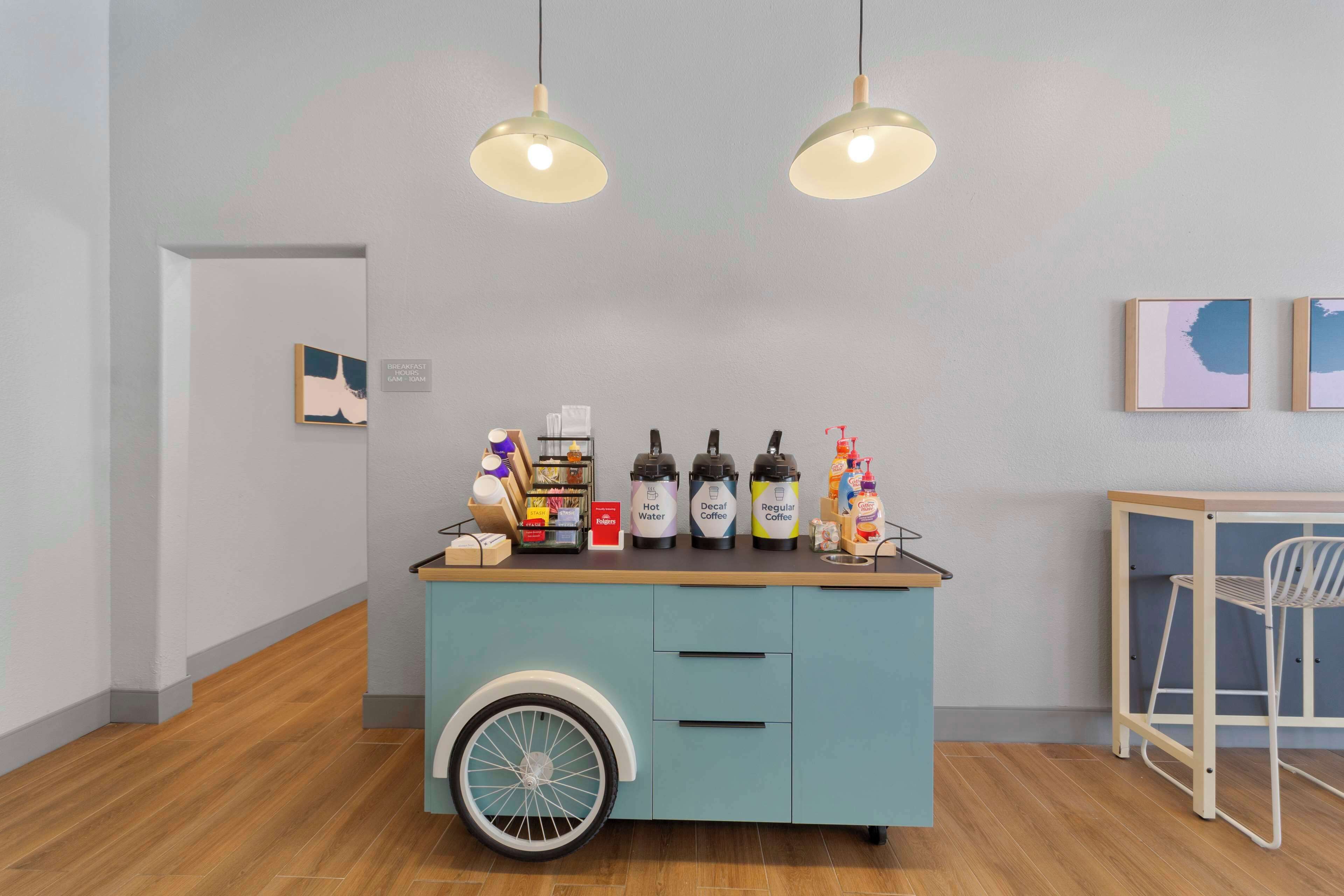 A kitchenette with a blue cabinet, a bicycle wheel, and various appliances.