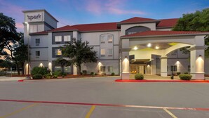 A hotel with a modern design, featuring a prominent entrance with a covered walkway and multiple windows. - Spark by Hilton San Antonio Dominion (San Antonio)