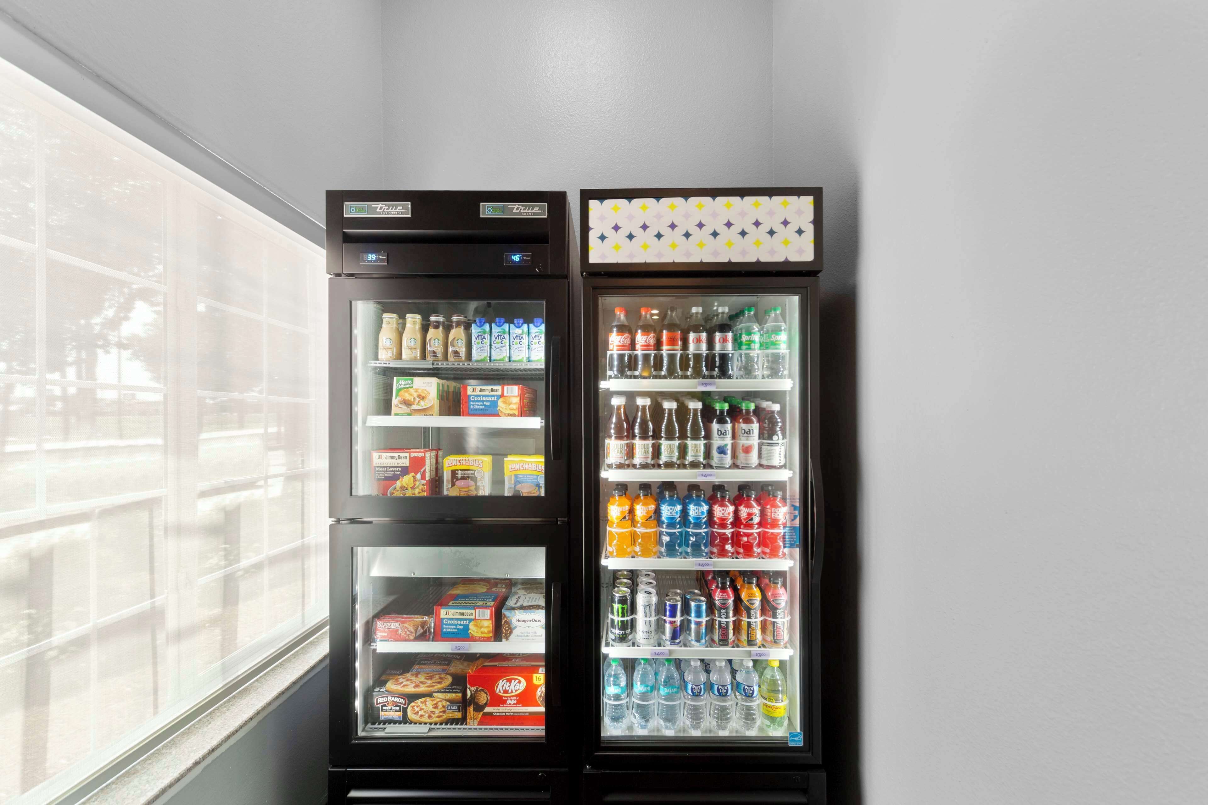 Deux distributeurs automatiques de boissons proposant une variété de boissons et d’en-cas.