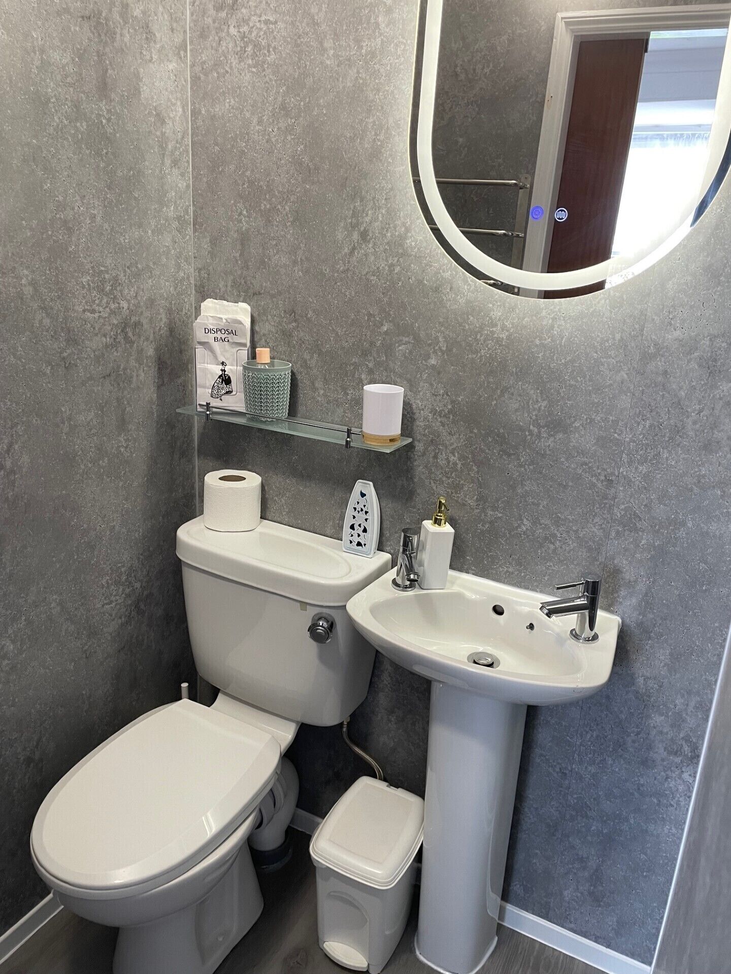 A bathroom with a toilet, bidet, sink, and a mirror.