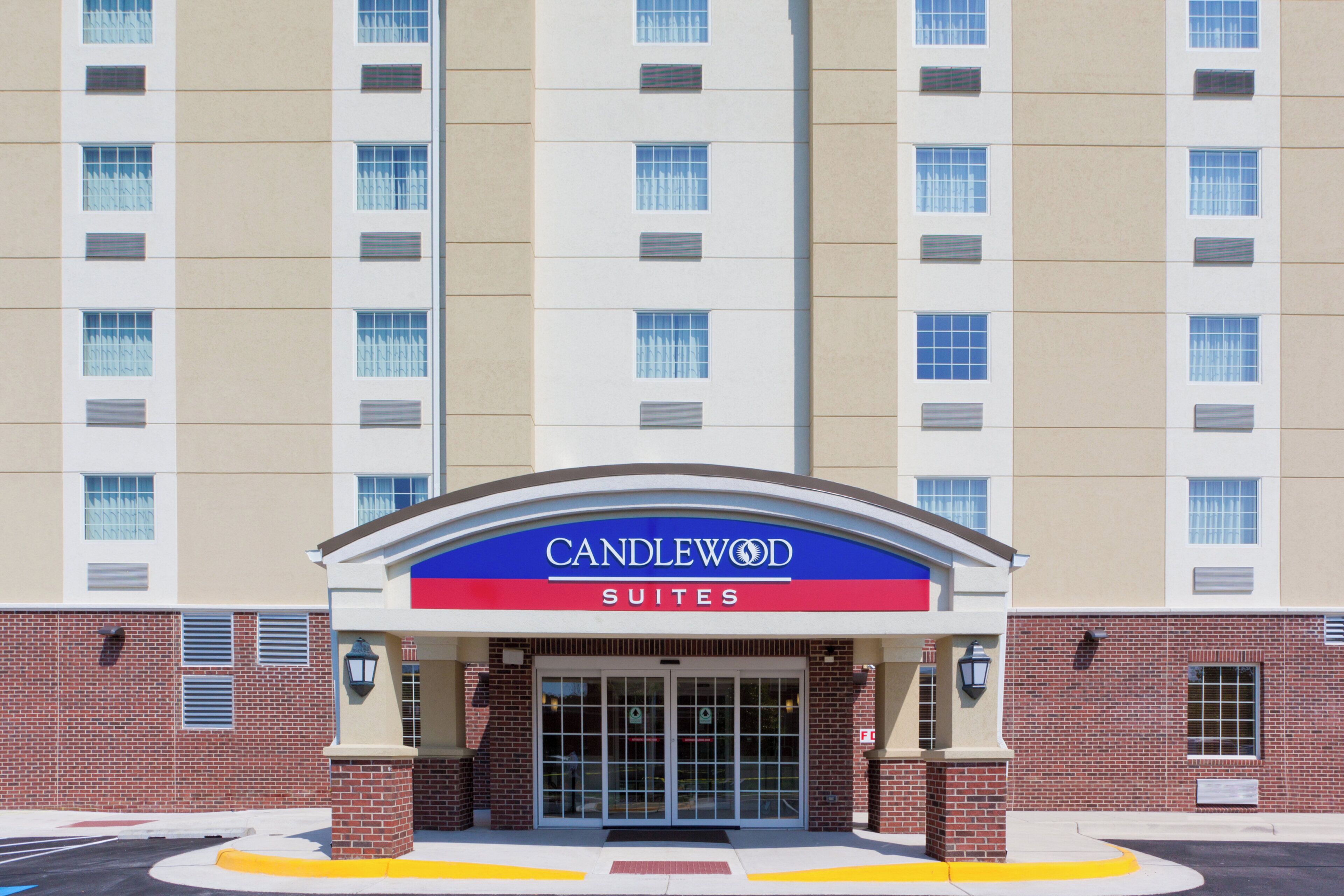 A hotel entrance with a sign reading 'CANDLEWOOD SUITES'.