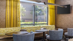 Un intérieur moderne avec un canapé, deux tables rondes et quatre chaises.