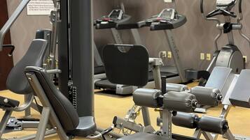 A gym with various exercise equipment including treadmills, a stationary bike, and weight machines.