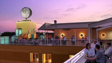 Eine Rooftop-Bar mit Mondblick, Außenbereich und einem Gebäude mit beleuchteten Fenstern.