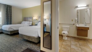 Ein Hotelzimmer mit zwei Betten und einem Badezimmer, das eine Toilette, ein Waschbecken und einen Spiegel enthält.