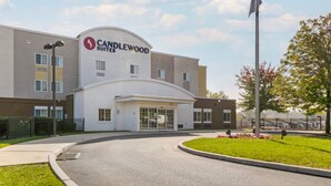 A hotel with a modern design, featuring a curved entrance and a prominent logo. - Candlewood Suites Reading by IHG (West Reading)
