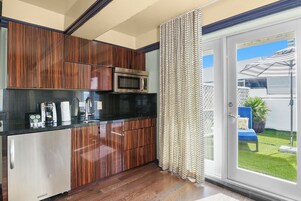 Una cocina moderna con armarios de madera, un microondas de acero inoxidable y una encimera negra.