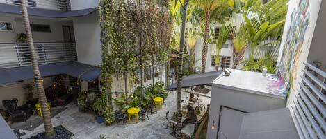 A multi-level courtyard with outdoor seating, plants, and a mural.