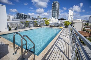 A rooftop pool with a clear view of the city skyline, including high-rise buildings and a clear sky. - Riviera Hotel South Beach (Miami Beach)
