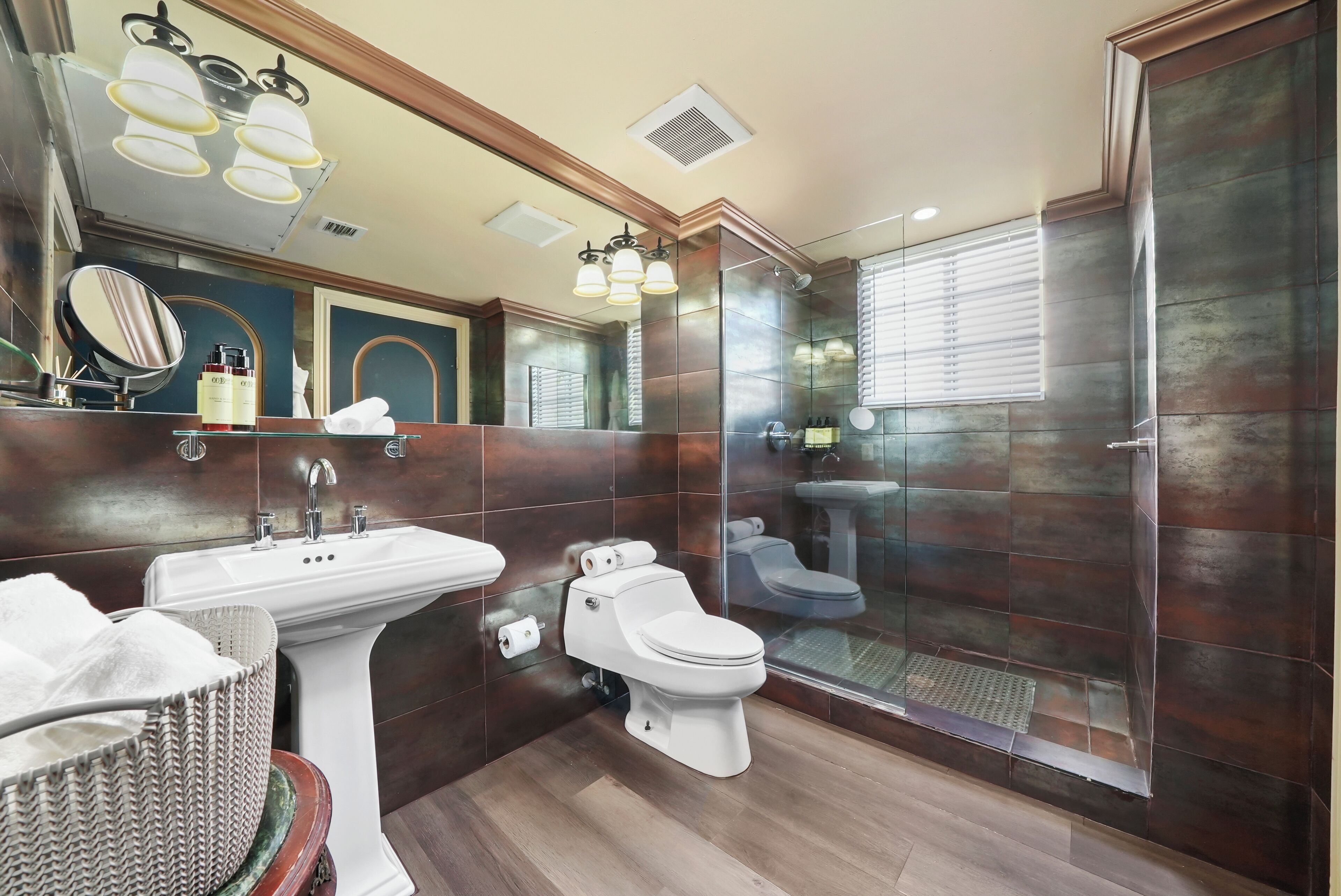 Une salle de bain moderne avec un lavabo sur colonne, des toilettes et un espace douche.