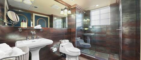 Une salle de bain moderne avec un lavabo sur colonne, des toilettes et un espace douche.