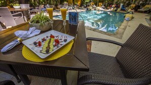 A dining table with a plate of food, a glass of orange juice, and a menu. - Riviera Hotel South Beach (Miami Beach)