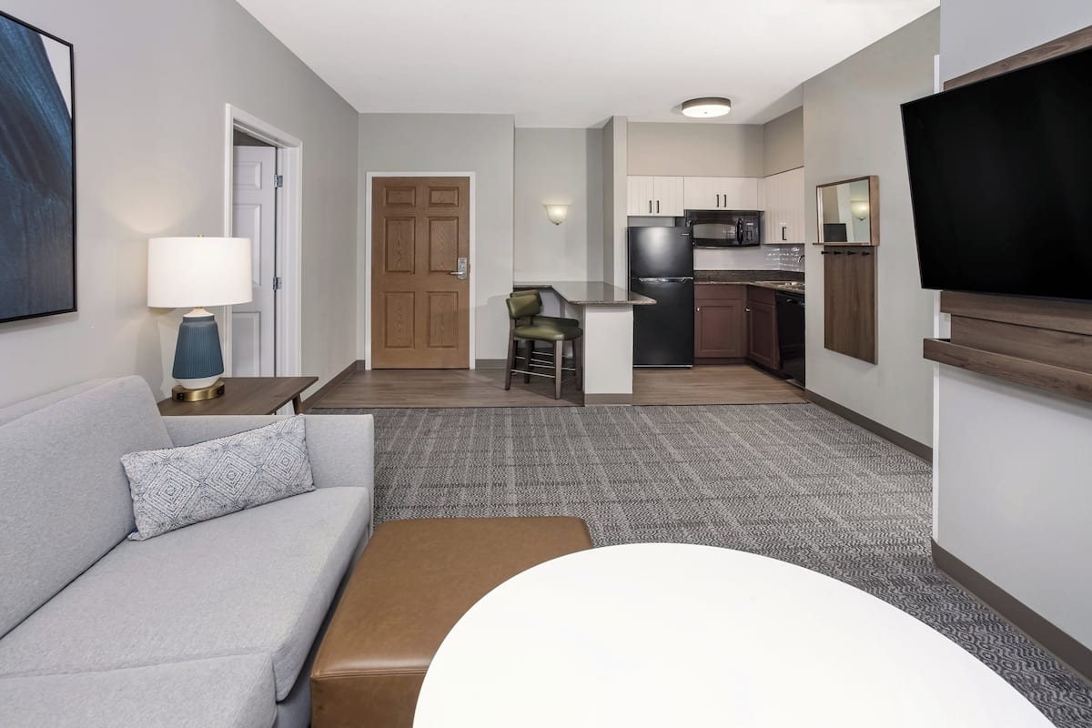 Escritorio, cortinas blackout y tabla de planchar con plancha