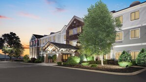 A multi-story hotel with a modern architectural design, featuring a covered entrance and landscaped gardens. - Staybridge Suites Williamsville Buffalo by IHG (Buffalo)