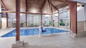 An indoor swimming pool with clear views of the outdoors through large windows, a wooden ceiling, and a lifeguard stand. - Staybridge Suites Williamsville Buffalo by IHG (Buffalo)