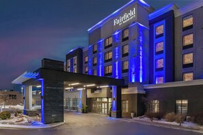 Un hotel con fachada moderna, varios accesos y un cartel que indica que es un establecimiento Fairfield by Marriott.