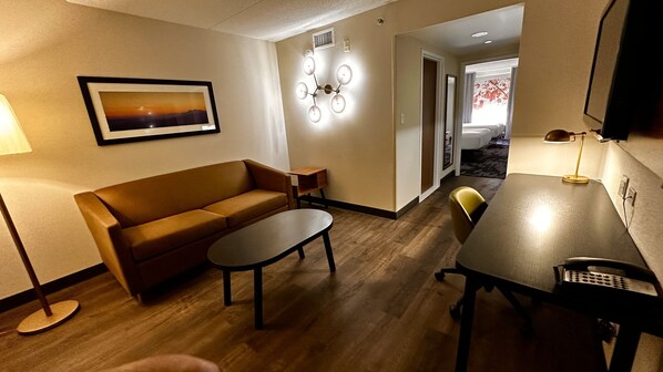 Relax in this stylish living room with a comfortable sofa, dining table, and modern light fixture.