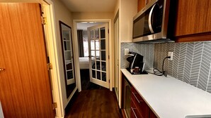 A narrow kitchen with wooden cabinets, a microwave, and a coffee maker on the counter. - Fairfield by Marriott Inn & Suites Newmarket (Newmarket)