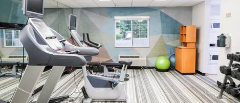 A fitness center with treadmills, stationary bikes, and exercise balls.
