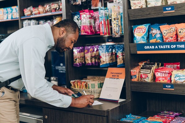 Una persona en un mostrador de tienda firmando un documento.