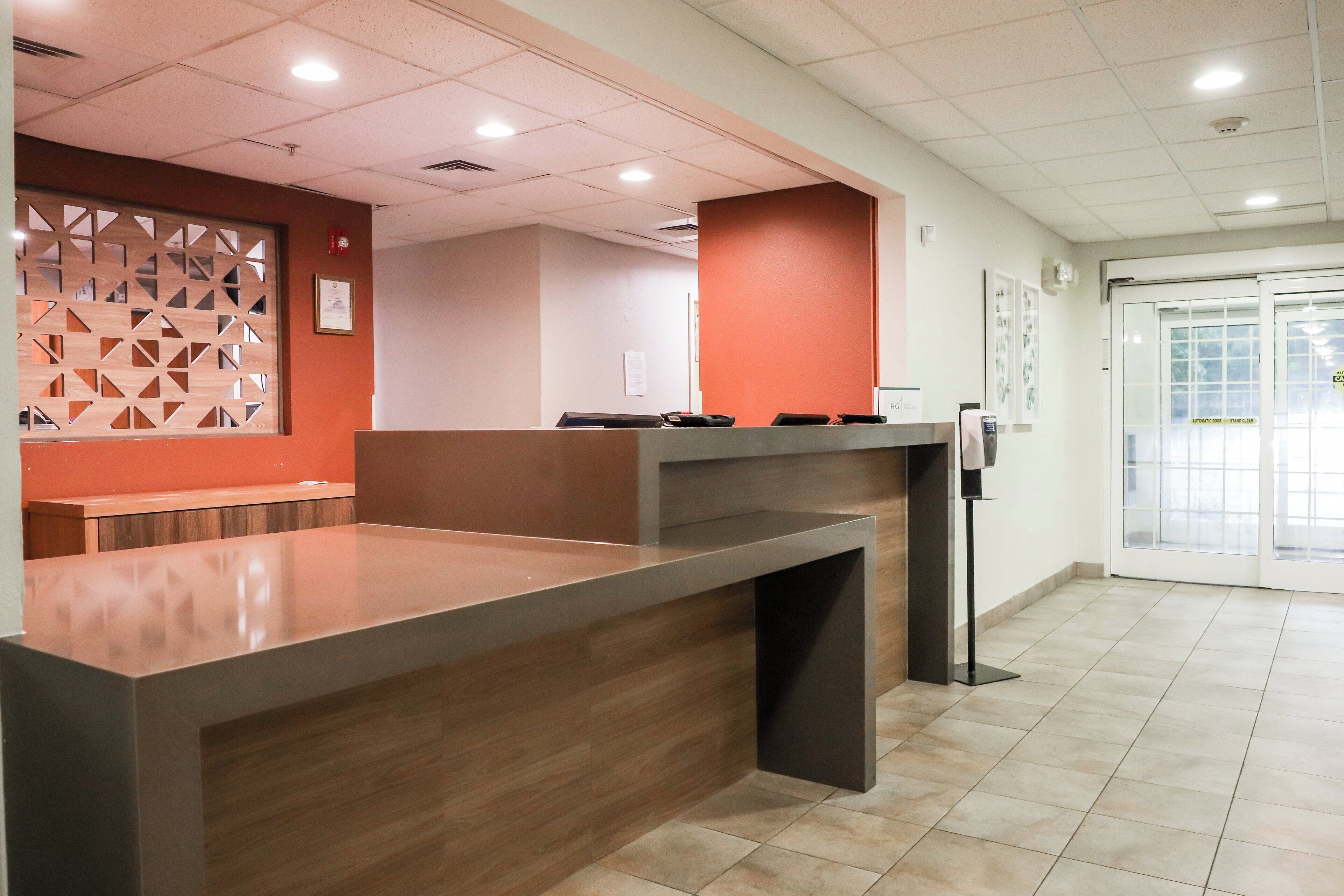 Un mostrador de recepción de diseño moderno, con un separador de madera y piso de baldosas.