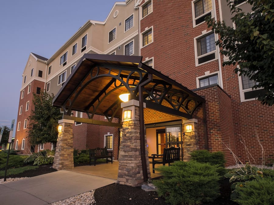 A multi-story building with a covered entrance and stone pillars.