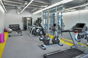 A modern gym with treadmills, elliptical machines, and weightlifting equipment. - Aloft by Marriott Dulles Airport North (Ashburn)