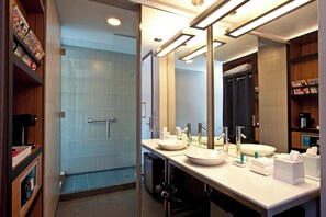 A modern bathroom with two sinks, a large mirror, and a shower area. - Aloft by Marriott Dulles Airport North (Ashburn)