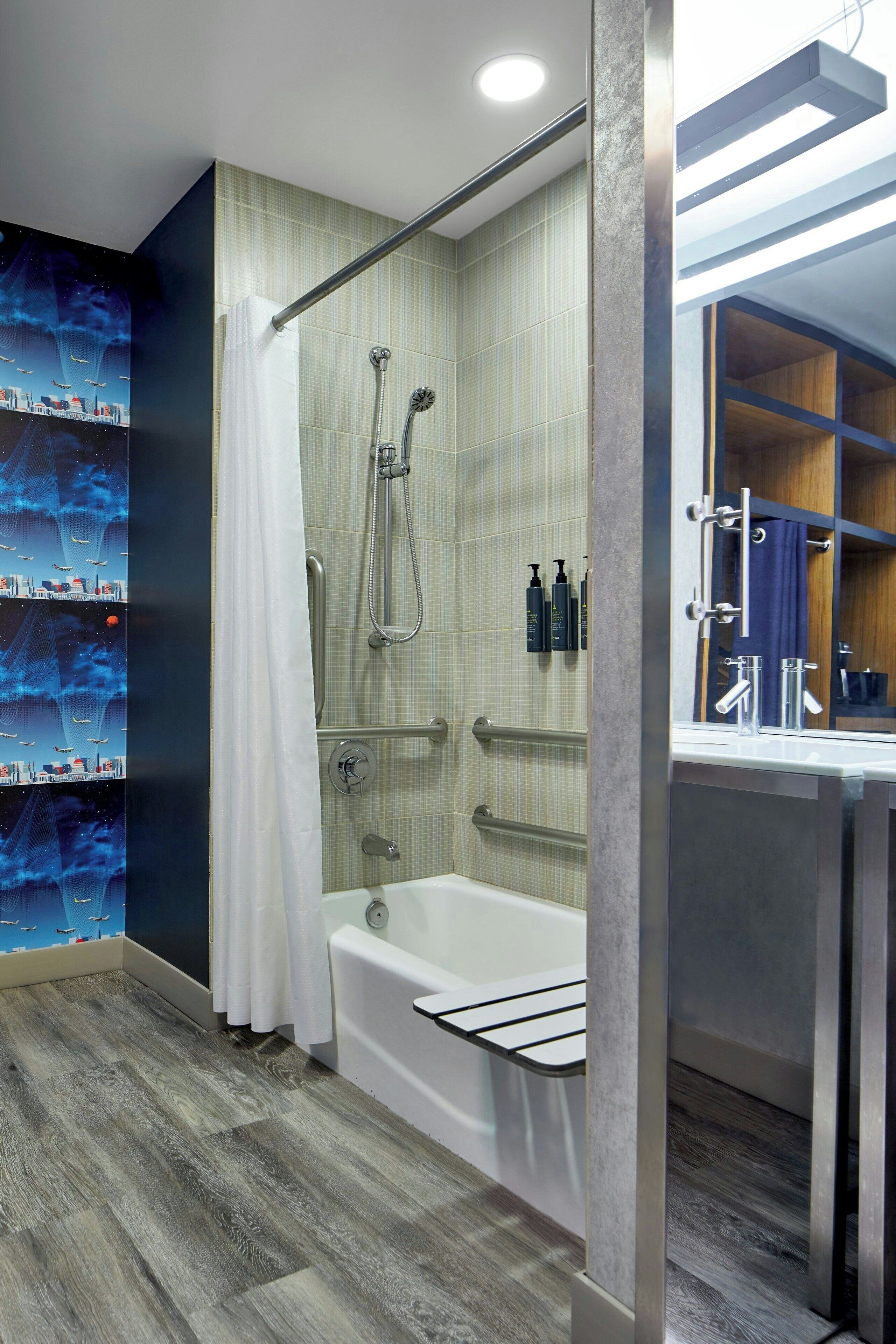 Een moderne badkamer met een douche, bad en een wastafel met spiegel.