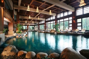 A large indoor swimming pool with natural rock formations and lounge chairs. - Howard Johnson Conference Resort Chengdu (Chengdu)