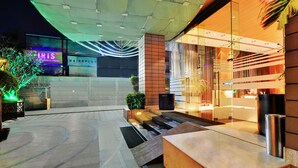 L’entrée d’un hôtel, dotée d’un design moderne, comprend un comptoir d’accueil, un espace salon et un escalier menant au hall d’entrée.