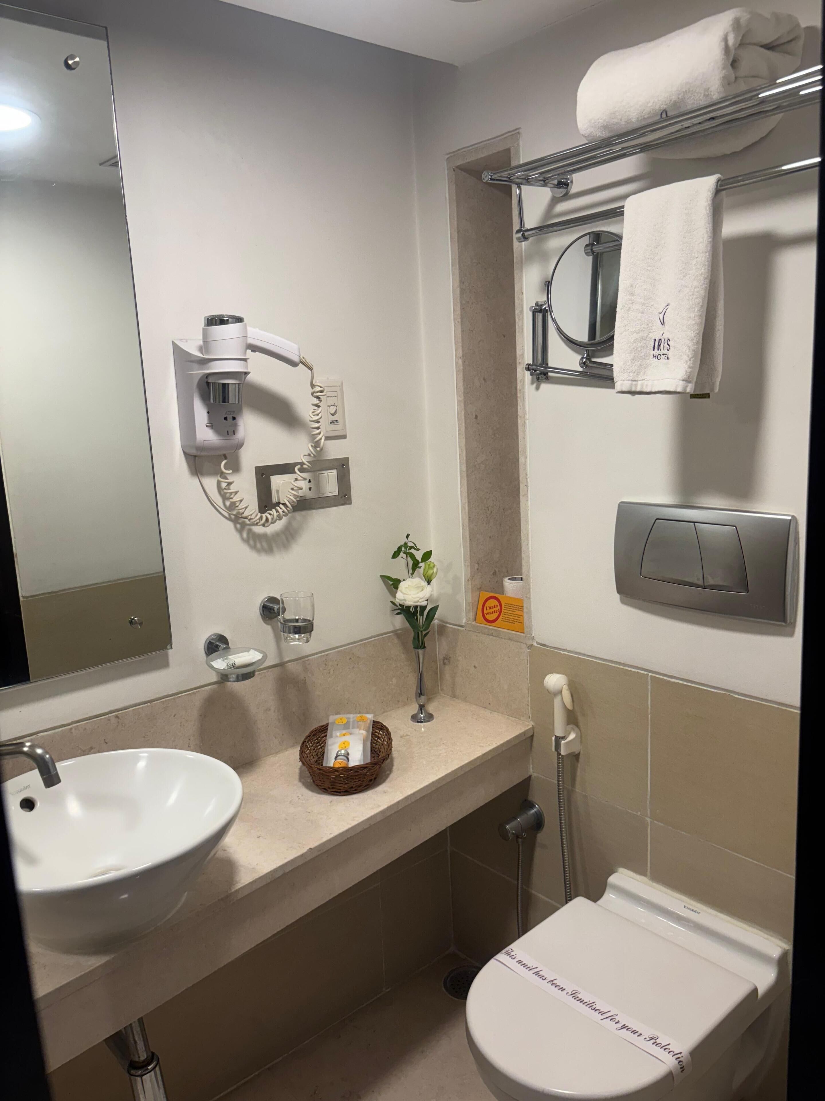 A modern bathroom with a sink, toilet, and towel rack.