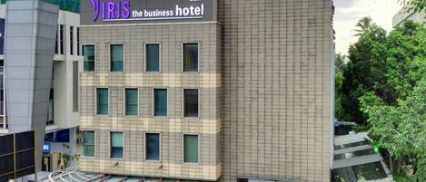 A modern hotel with a prominent sign for 'IRIS the business hotel' and a restaurant named 'Chef Pilla'.