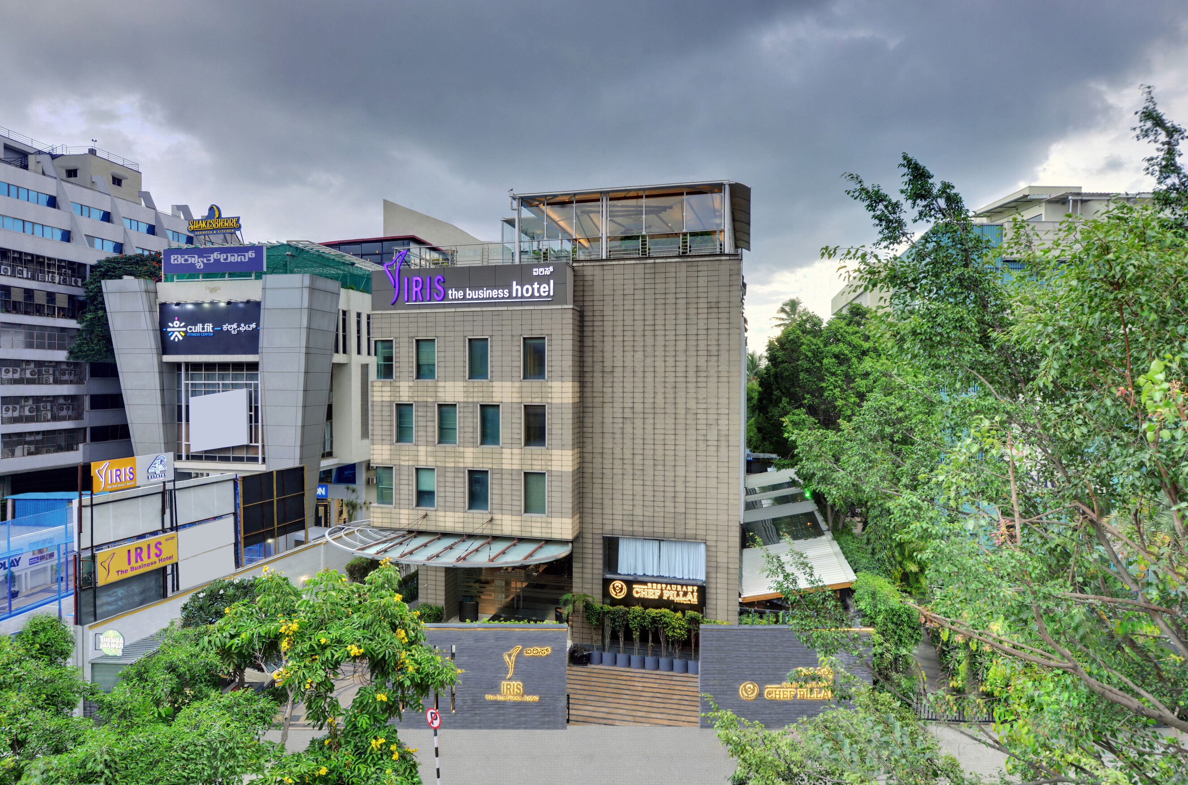 A modern hotel with multiple floors, a prominent business hotel sign, and a restaurant named 'Chef Piyali' at the ground level.