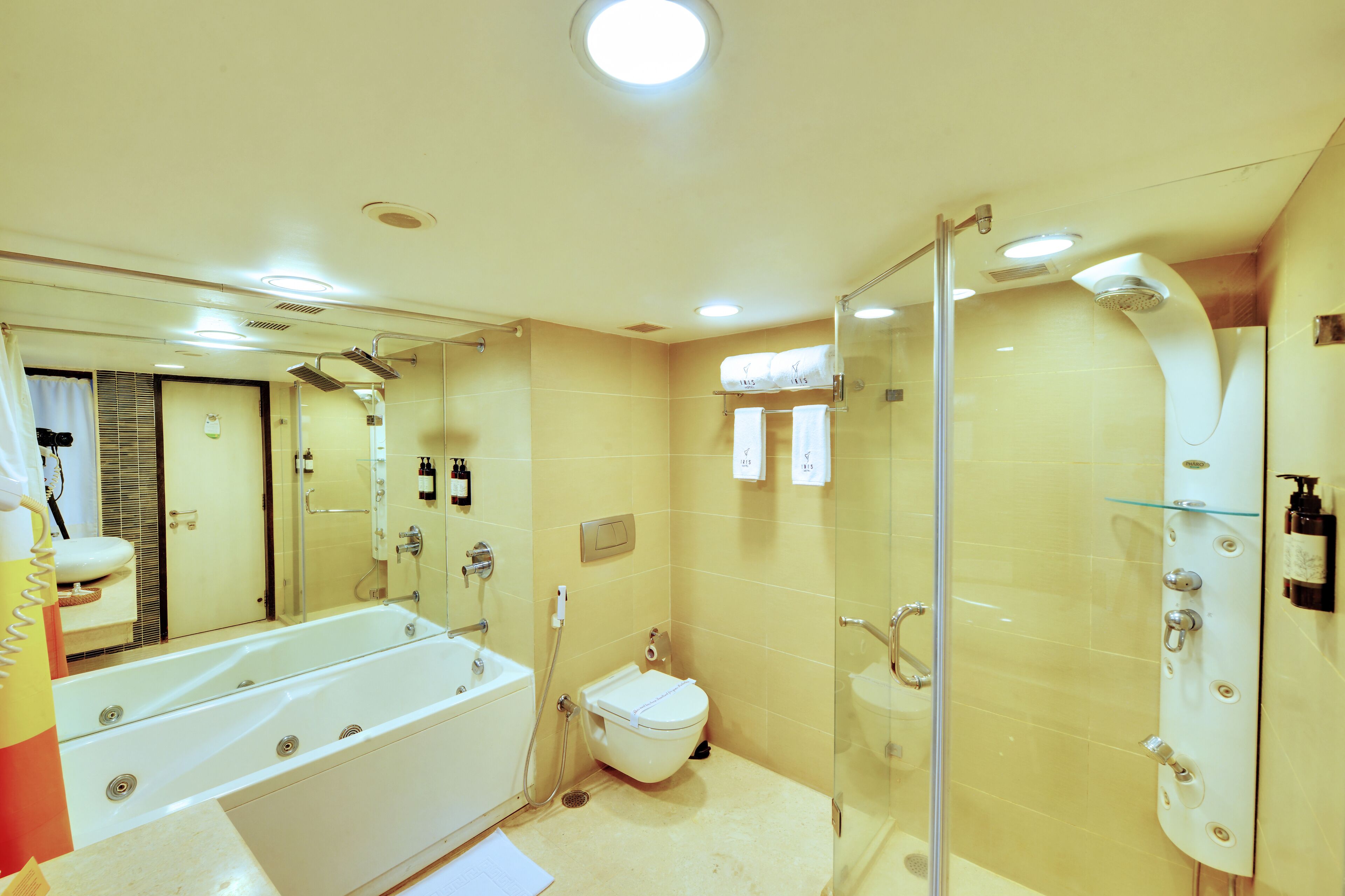 A modern bathroom with a bathtub, toilet, and glass-enclosed shower area.