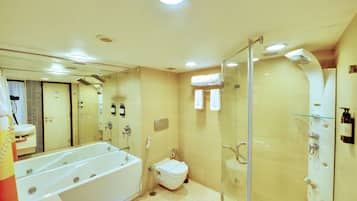 Un baño moderno con bañera, inodoro y zona de ducha con mampara de vidrio.