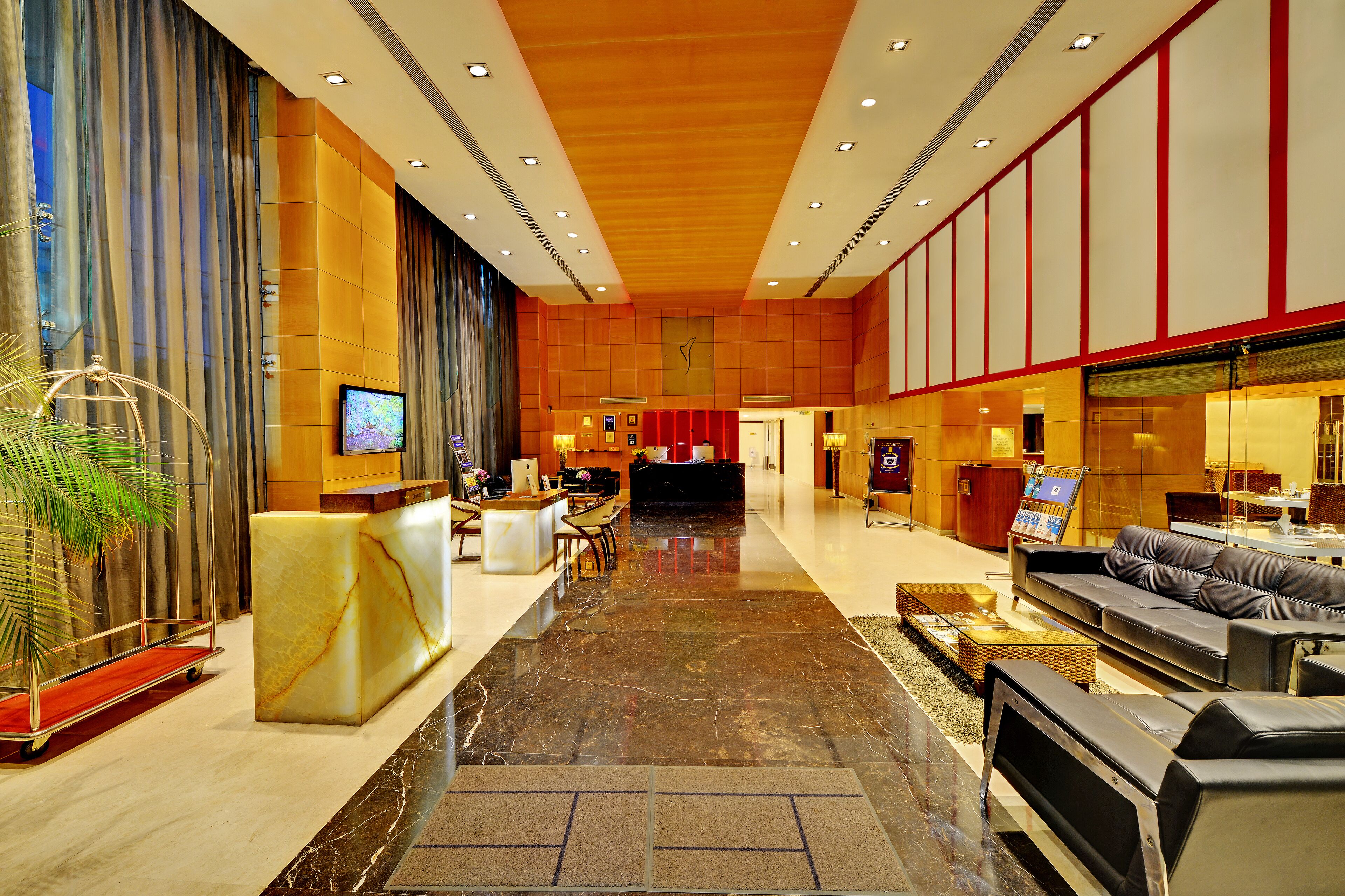 Eine geräumige Lobby mit einer Rezeption, einer Sitzecke und einer großen Uhr an der Wand.