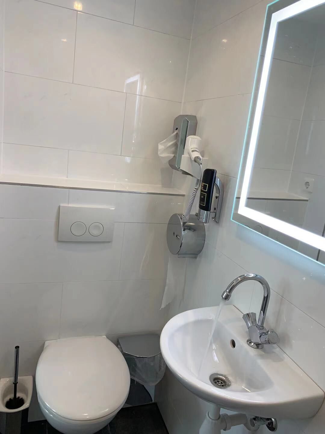 Uma casa de banho moderna com sanita, bidé e lavatório.