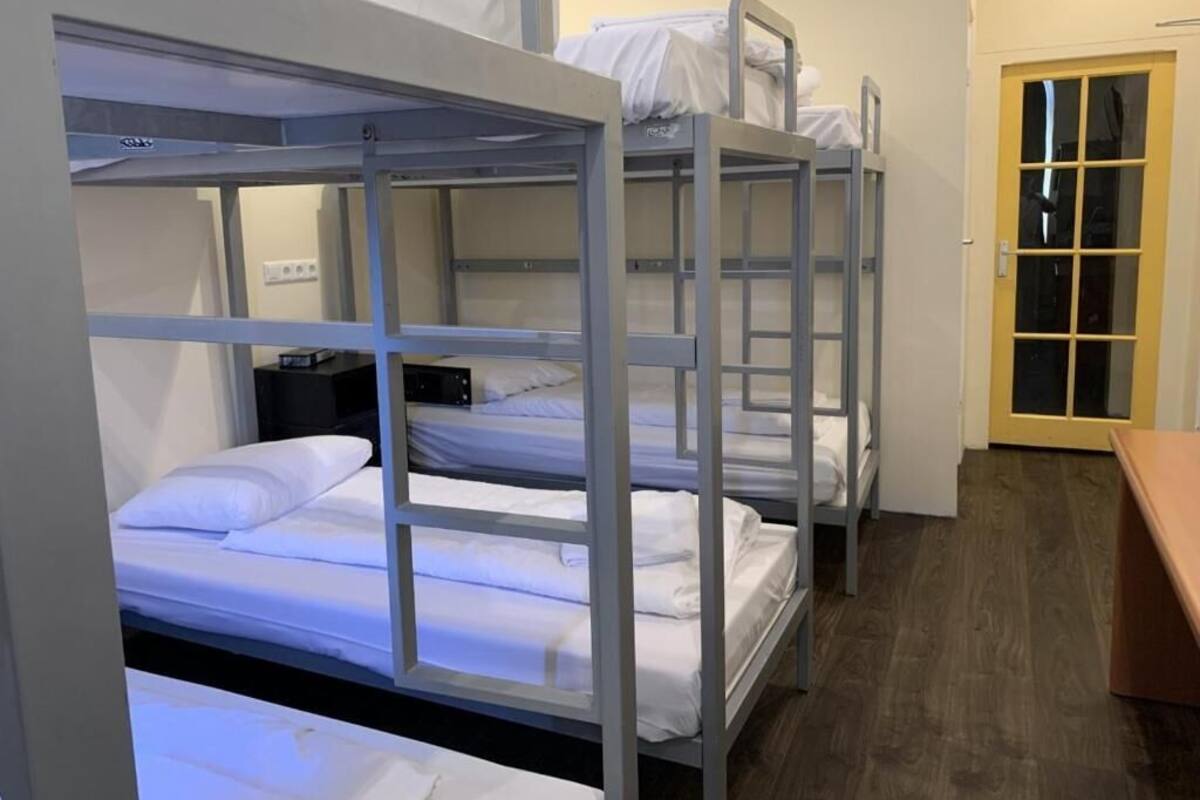 Bunk beds in a room with a wooden floor and a door with glass panels.
