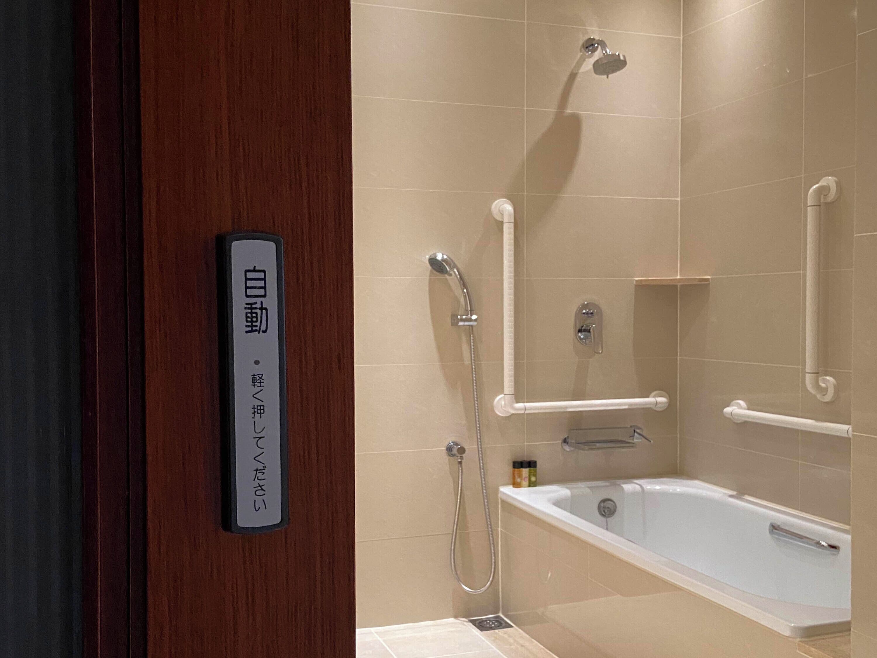 バリアフリールーム  キングベッド | バスルーム | 個別の浴槽とシャワー、深めの浴槽、レインフォールシャワー、ヘアドライヤー