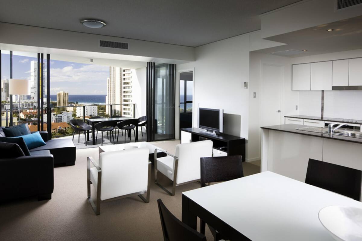 Eine moderne Wohnung mit Balkon, Essbereich, Küche und Fernseher.