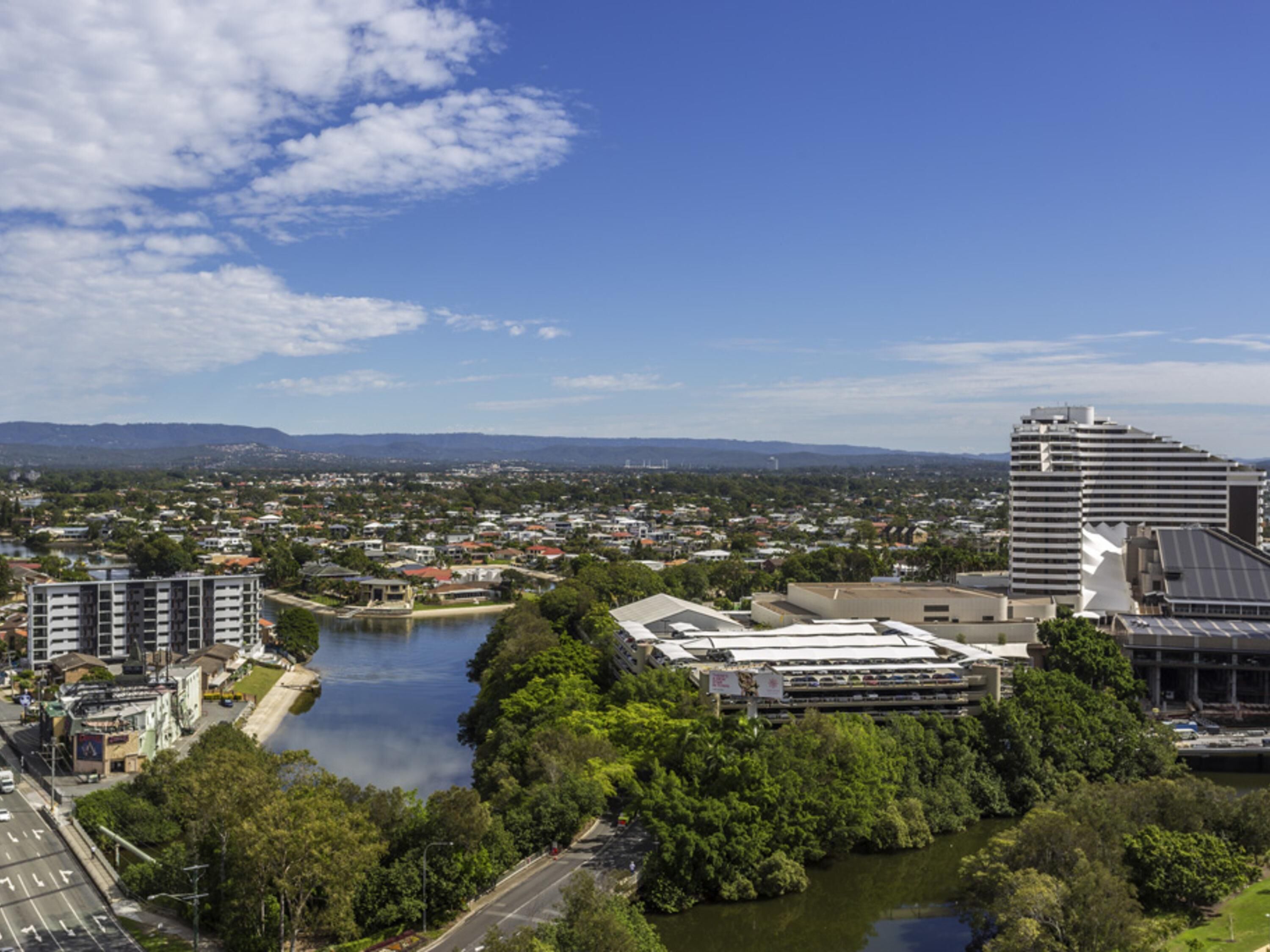 A cityscape with a river, buildings, and a large modern structure.