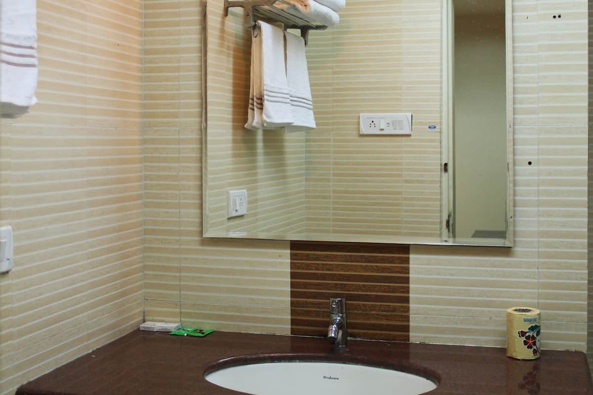A bathroom with a sink, mirror, towel rack, and a light fixture.