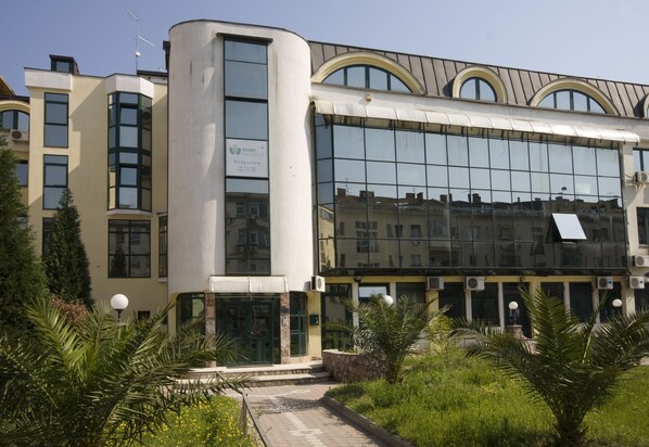 Un edificio moderno con amplias ventanas, techo curvo y un letrero que indica que es un colegio.