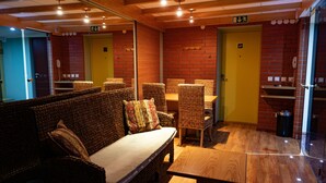 A room with wicker furniture, a wooden table, and a yellow door. - Tahetorni Hotel (Tallinn)