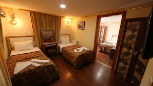 A hotel room with two beds, a mirror, a TV, and a door leading to another room. - Meddusa Hotel (Istanbul)